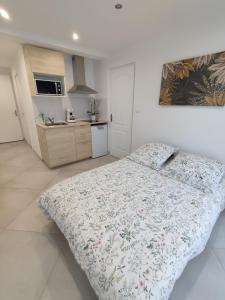 a bedroom with a bed and a kitchen at Studio Beauvais avec terrasse privative calme & tout confort in Beauvais