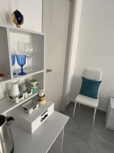 a white room with a chair and a white cabinet at La casa di Fiore in Vico Equense +5 photos