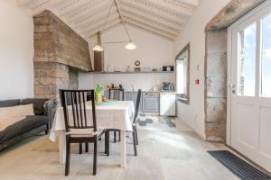 a kitchen and dining room with a table and chairs at Casas do Forneiro - T1 in Nordeste