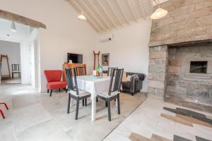 a living room with a table and a fireplace at Casas do Forneiro - T1 in Nordeste