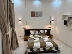a bedroom with a bed and two lights on the wall at Appartement Kekely in Yovo Kopé