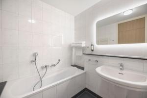 ein weißes Badezimmer mit Badewanne und Waschbecken in der Unterkunft Van der Valk Hotel Eindhoven in Eindhoven