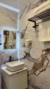 a marble bathroom with a sink and a mirror at Sim Plaza Hotel in Ejmiatsin +124 photos