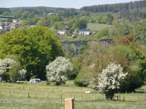 a stone bridge over a field with trees and animals at SLEEP INN Bed&Breakfast in Amblève
