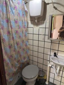a small bathroom with a toilet and a sink at Chalé do Ben in São Thomé das Letras