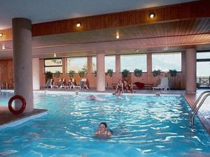 a woman swimming in a large swimming pool at APPARTAMENTI LATEMAR con PISCINA e SAUNA in Cavalese