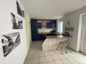 a kitchen with blue cabinets and a table and chairs at Ferienwohnung Karin in Losheim +2 photos