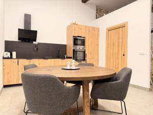 a kitchen with a wooden table and chairs at Apartamento Calle Limón in Santander +8 photos