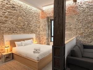 a bedroom with a bed and a chair and a brick wall at Apartamento Calle Limón in Santander