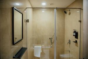 a bathroom with a shower with a glass door at Varanashi Inn in Tiruppūr
