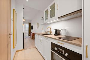 a kitchen with white cabinets and a sink at Marienholm Seaside Studio in Haapsalu