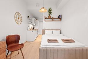 a bedroom with a large bed and a chair at Marienholm Seaside Studio in Haapsalu