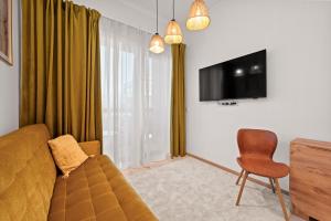 a living room with a couch and a chair and a tv at Marienholm Seaside Studio in Haapsalu