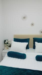 a bed with blue and white pillows on it at Apartman,, Nina ,, in Jagodina