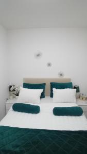 a large white bed with two green pillows on it at Apartman,, Nina ,, in Jagodina +5 photos