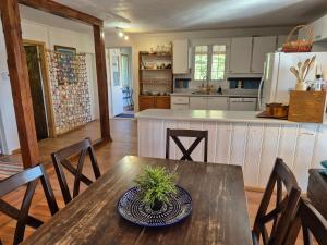 a kitchen with a wooden table and a dining room at Villa de la Montagne VUE sur le Fjord in Sainte-Rose-du-Nord