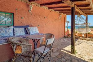 a patio with a table and chairs and a couch at Villaggio Marineledda in Santa Marinella