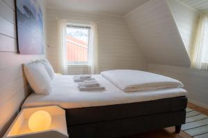 a small bed in a room with a window at Henningsvær Rorbuer in Henningsvær