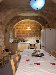 a kitchen with a table with red flowers on it at Serenity Wellness Farmhouse With Private Sauna in Nadur