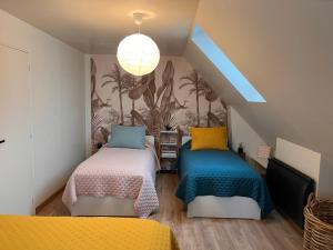 a room with two beds with colorful sheets at Honfleur - grande maison familiale avec jardin in Honfleur
