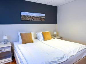 a bedroom with a large white bed with yellow pillows at Sel - Hótel Mývatn in Myvatn