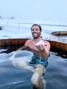 a man in the water in a bath tub at Sel - Hótel Mývatn in Myvatn