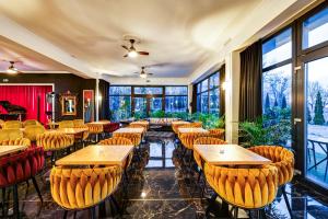 a restaurant with wooden tables and chairs and windows at Hotel Południk Park Conference&SPA in Stargard