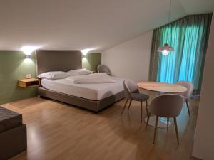 a bedroom with a bed and a table and chairs at Garni Saltneregg Ferienwohnungen in Caldaro