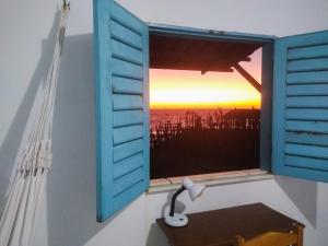 a window with a view of a sunset at Casinha Estrela do Mar o Oceano aos seus Pés in Aracati +28 photos