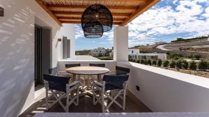 a patio with a table and chairs on a balcony at Double Pool Villa Ι in Kampos Paros