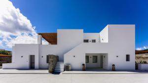 a white house with a blue sky in the background at Double Pool Villa Ι in Kampos Paros