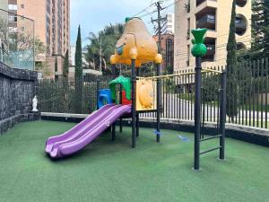 a playground with a purple slide in a park at 2003 Poblado TOP apartamento in Medellín