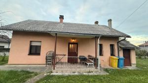 a small pink house with a porch and a gate at Magnolia guest house in Karlovac