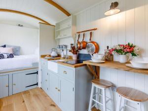 a kitchen with white cabinets and a sink and a bed at 1 Bed in Boscastle oc-84015 in Boscastle