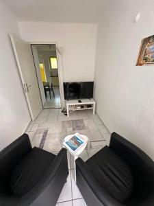 a living room with two black couches and a table at Gemütliche Wohnung im Borgo Ascona in Ascona