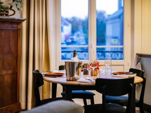 a table with a bottle of wine on it next to a window at Baie Marine in Le Crotoy