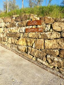 a stone wall with two street signs on it at Agriturismo Colle Sereno in Castiglione dʼOrcia