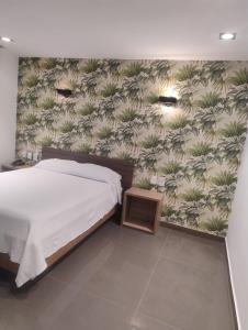 a bedroom with a bed and a wall with plants at Real Hotel in Juiz de Fora +30 photos