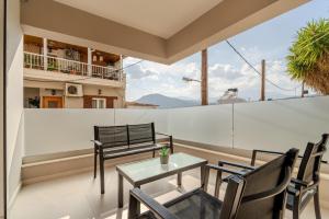 a balcony with a table and chairs and a view at M P A Luxury Apartment Α2 in Agios Nikolaos
