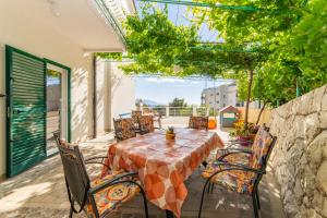 a patio with a table and chairs on a balcony at Apartments Palmero in Gradac