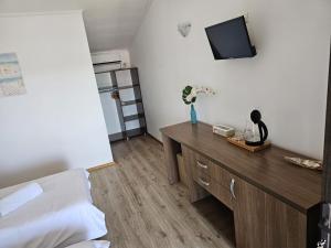 a bedroom with a bed and a tv on the wall at Vila Natalia in Vama Veche