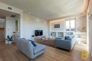 a living room with two chairs and a tv at BePlace Apartments Arona in Arona