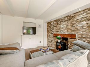 a living room with two couches and a stone wall at 3 Bed in Looe oc-92273 in Polperro