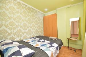 a bedroom with a bed and a wall at Apartment On Saryan Street in Yerevan