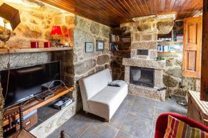 a stone room with a couch and a fireplace at Guest H4U - Nature & Pool Guarda in Seixo Amarelo