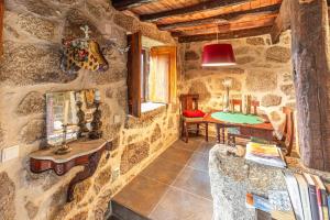 a room with a stone wall with a desk and a table at Guest H4U - Nature & Pool Guarda in Seixo Amarelo