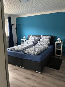 a bed in a room with a blue wall at Ferienwohnung Panorama in Konz