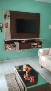 a living room with a couch and a tv at Acomodações em Bananeiras, PB in Bananeiras