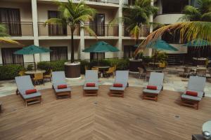 a hotel courtyard with chairs and tables and umbrellas at Afago Mareiro Hotel in Fortaleza