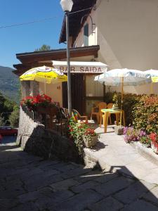 a patio with tables and umbrellas in front of a building at Il Paradiso Della Montagna in Cutigliano